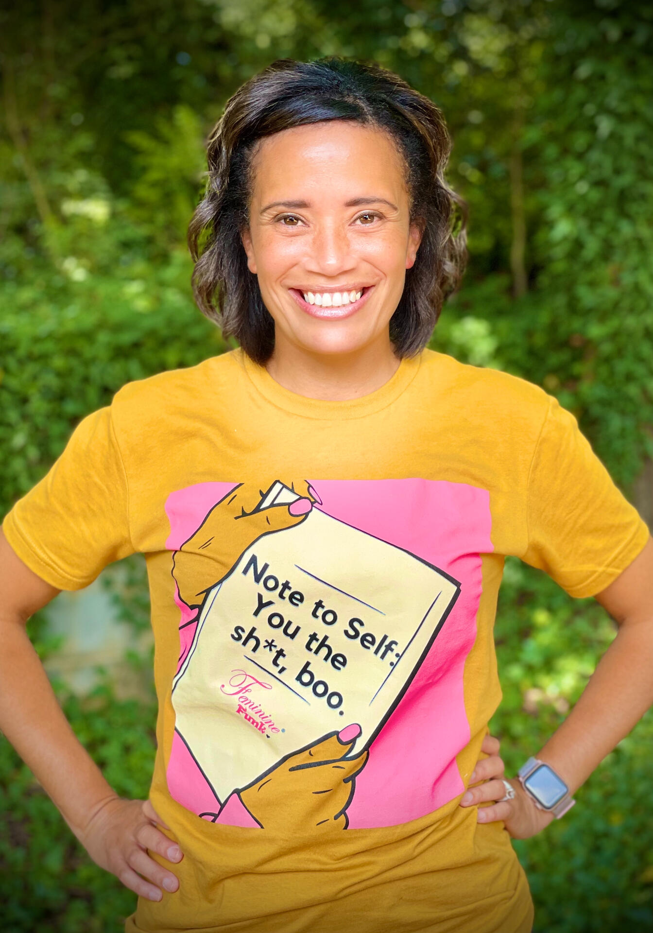 Photo of Amanda, smiling with arms crossed, and standing in front of a bookshelf