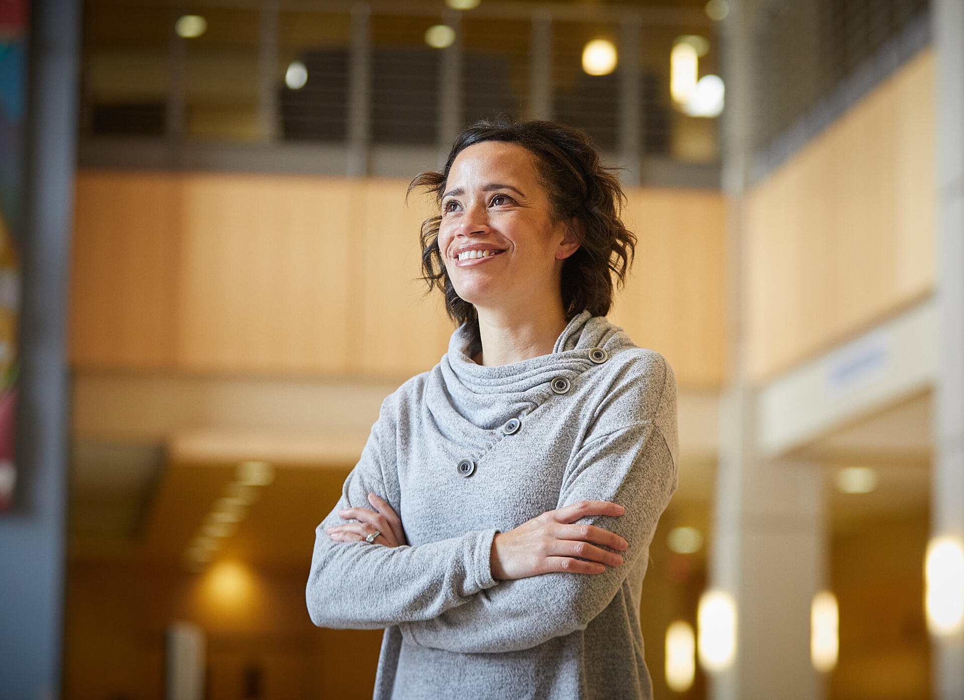Photo of Amanda gazing at a window, with arms crossed